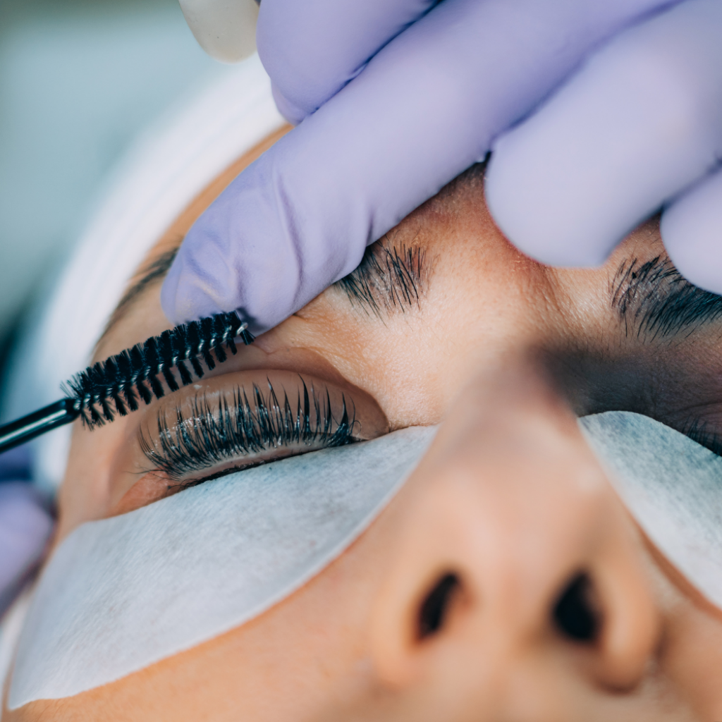 Kosmetikerin b&uuml;rstet die Augenbrauen einer Kundin in der Beautylounge.