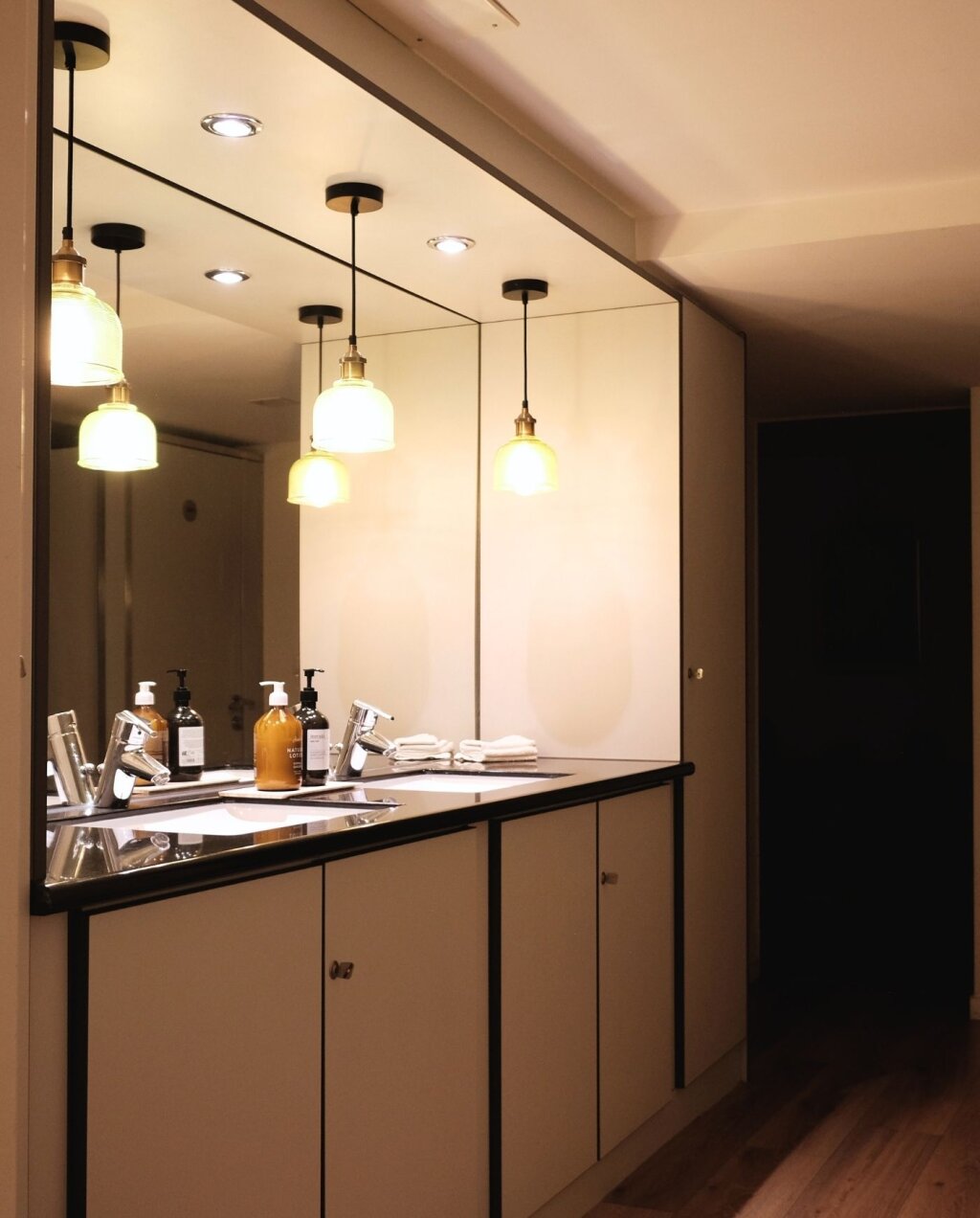 Ruhezone mit Spiegelwand und Pendelleuchten im Kosmetikstudio Beautylounge Oberwil.