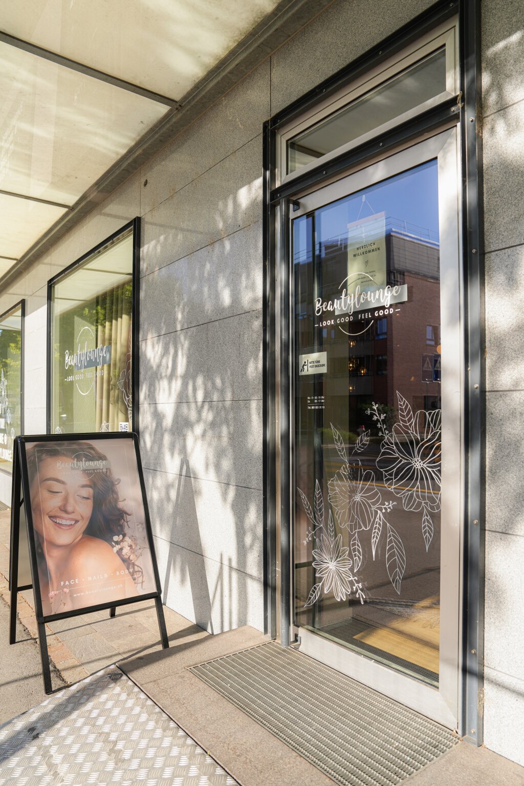 Eingang des Kosmetikstudios Beautylounge Pratteln mit Aufsteller vor der Glast&uuml;r.