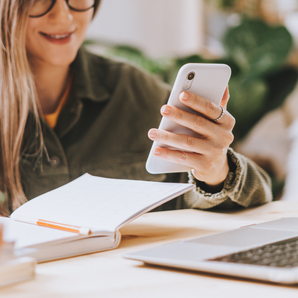 Frau bucht mit dem Smartphone einen Termin in der Beautylounge.