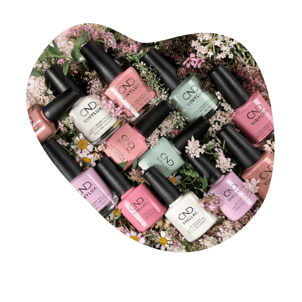 CND Shellac und Vinylux Flaschen in Rosa, Weiss, Mint und Nude zwischen Wiesenblumen und Kamille, Beautylounge Basel.
