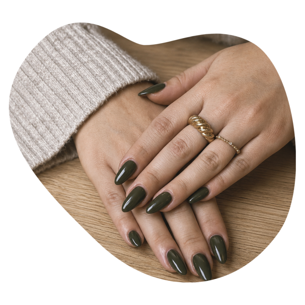 Olivgr&uuml;ne CND Shellac N&auml;gel mit goldenen Ringen auf einem Holztisch, Shellac Manicure bei Beautylounge Basel.