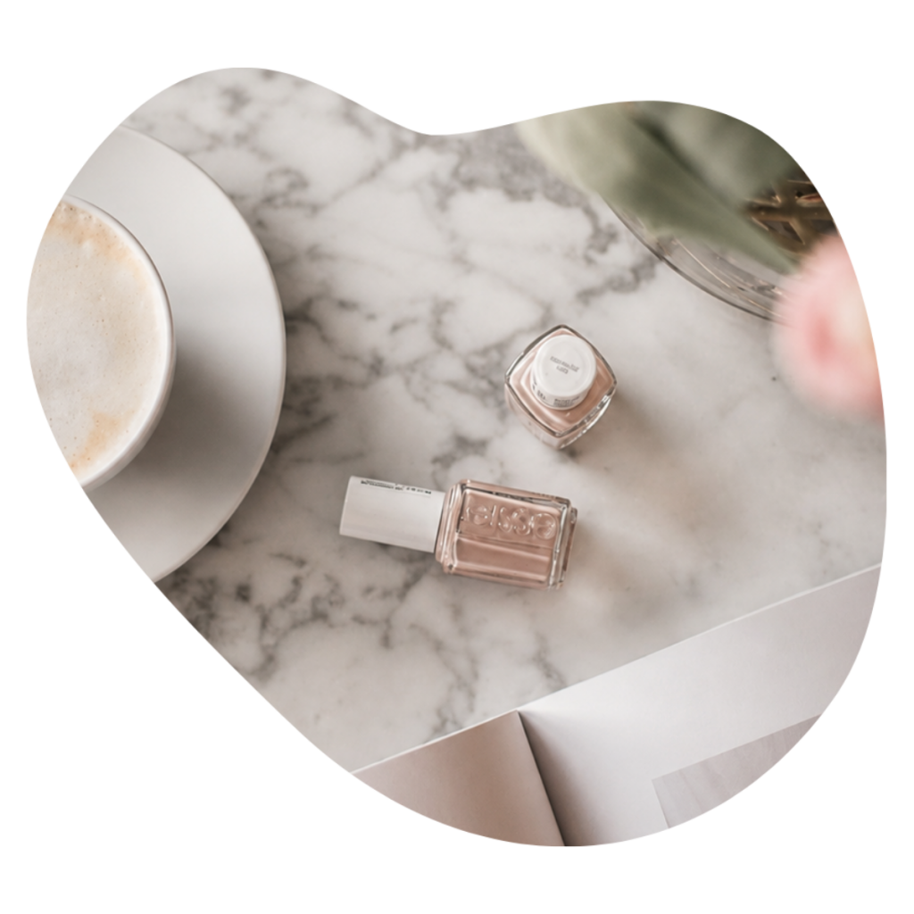 Essie Nagellack in Nude auf Marmor neben einem Cappuccino und Tulpen, Farbwahl f&uuml;r die Manicure bei Beautylounge Basel.
