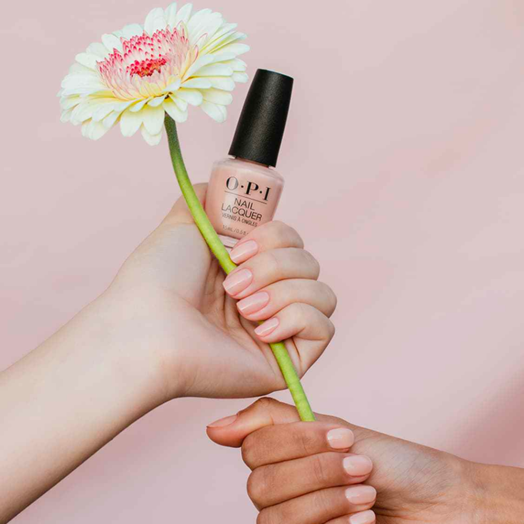 Hand mit O.P.I Nagellack und einer Blume, Nagelprodukte der Beautylounge Basel.
