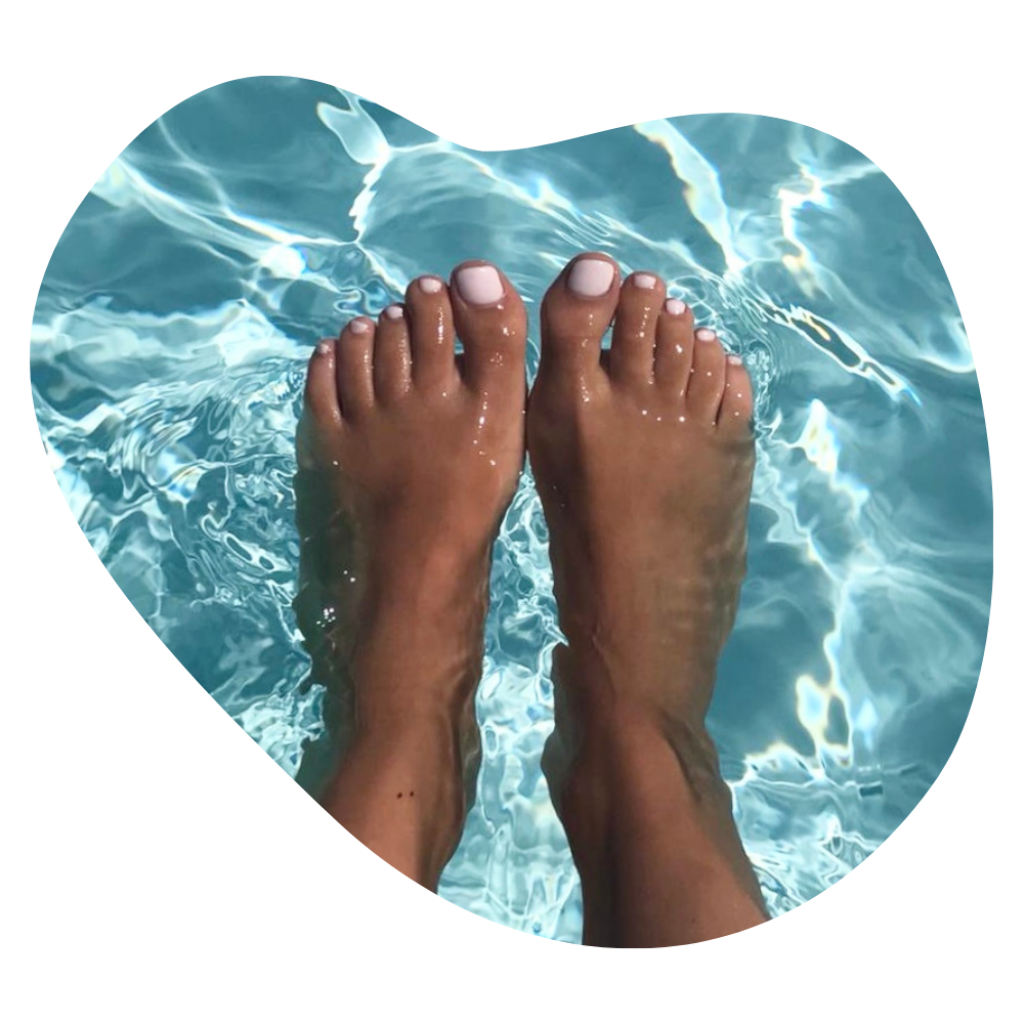F&uuml;sse mit weiss lackierten Zehenn&auml;geln im klaren Poolwasser nach einer Pedicure in Basel.
