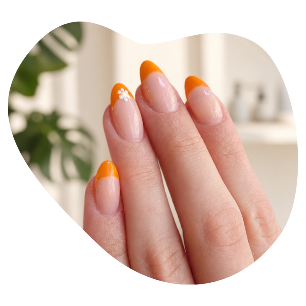 Hand mit orangefarbenen N&auml;geln im Kosmetikstudio Beautylounge.