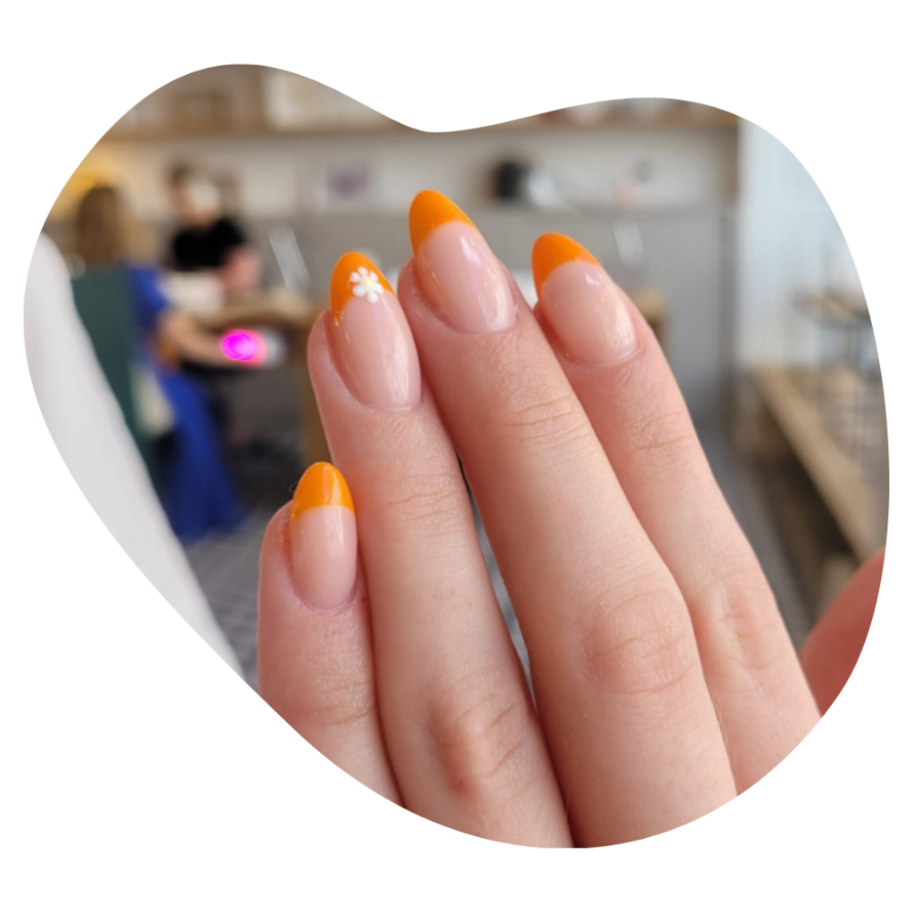 N&auml;gel in Orange mit Blumenmotiv, Naildesign der Beautylounge.