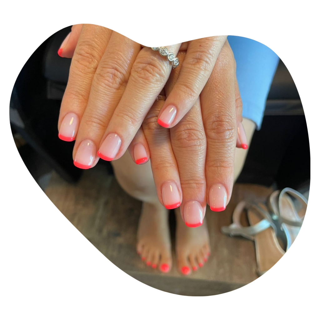 H&auml;nde und F&uuml;sse mit orangeroten French N&auml;geln nach Manicure und Pedicure in Basel.