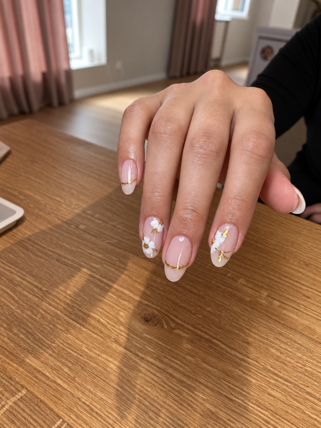 Naildeko mit weissen Bl&uuml;ten und goldenen Linien auf nude French N&auml;geln in der Beautylounge.