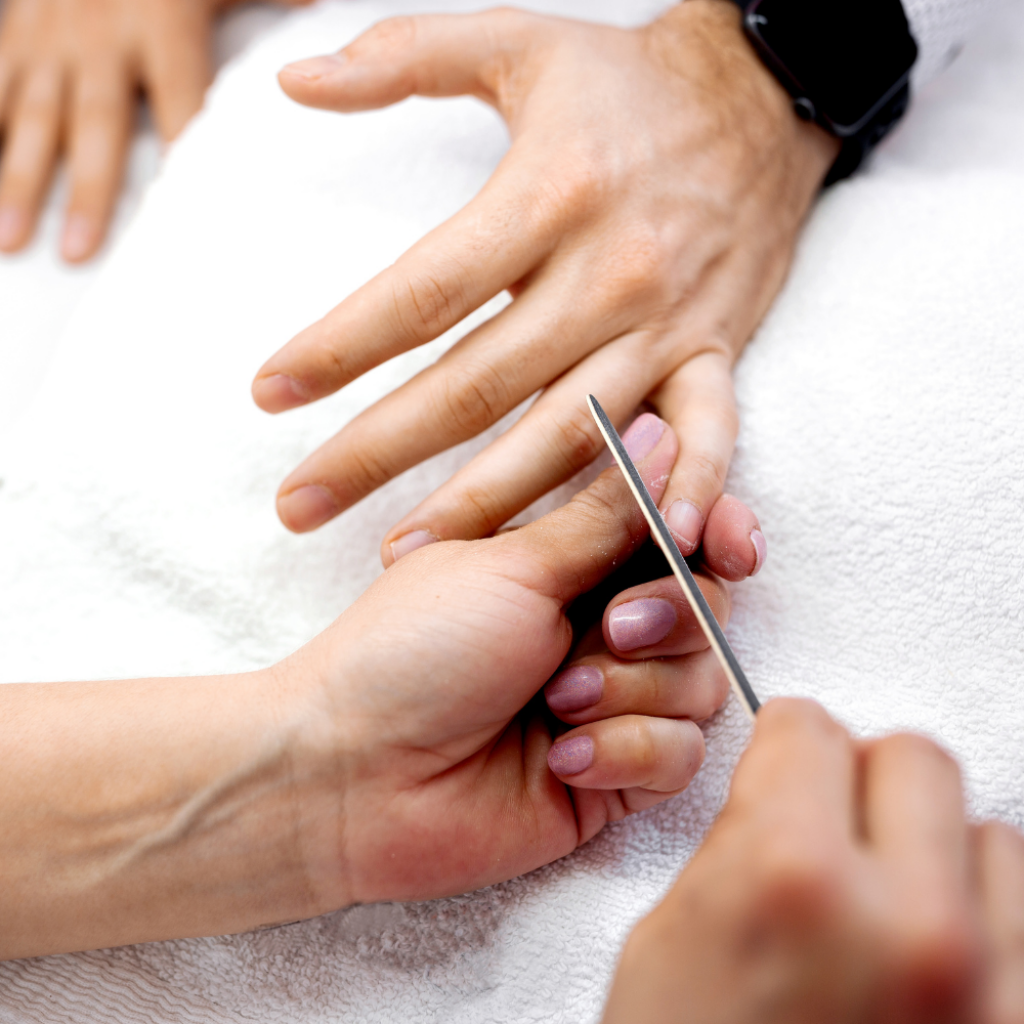 Nagelhaut an der M&auml;nnerhand wird mit dem Rosenholzst&auml;bchen zur&uuml;ckgeschoben, Manicure f&uuml;r M&auml;nner in Basel.