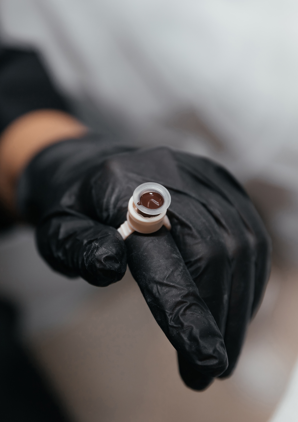 PMU Farbe im Fingerbecher wird f&uuml;r die Augenbrauenbehandlung vorbereitet, PMU in Basel.